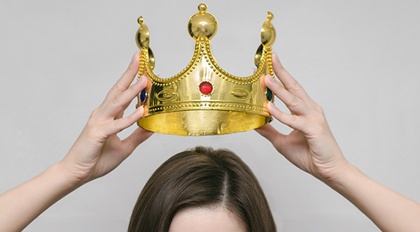 Woman girl holding above a head the golden crown.